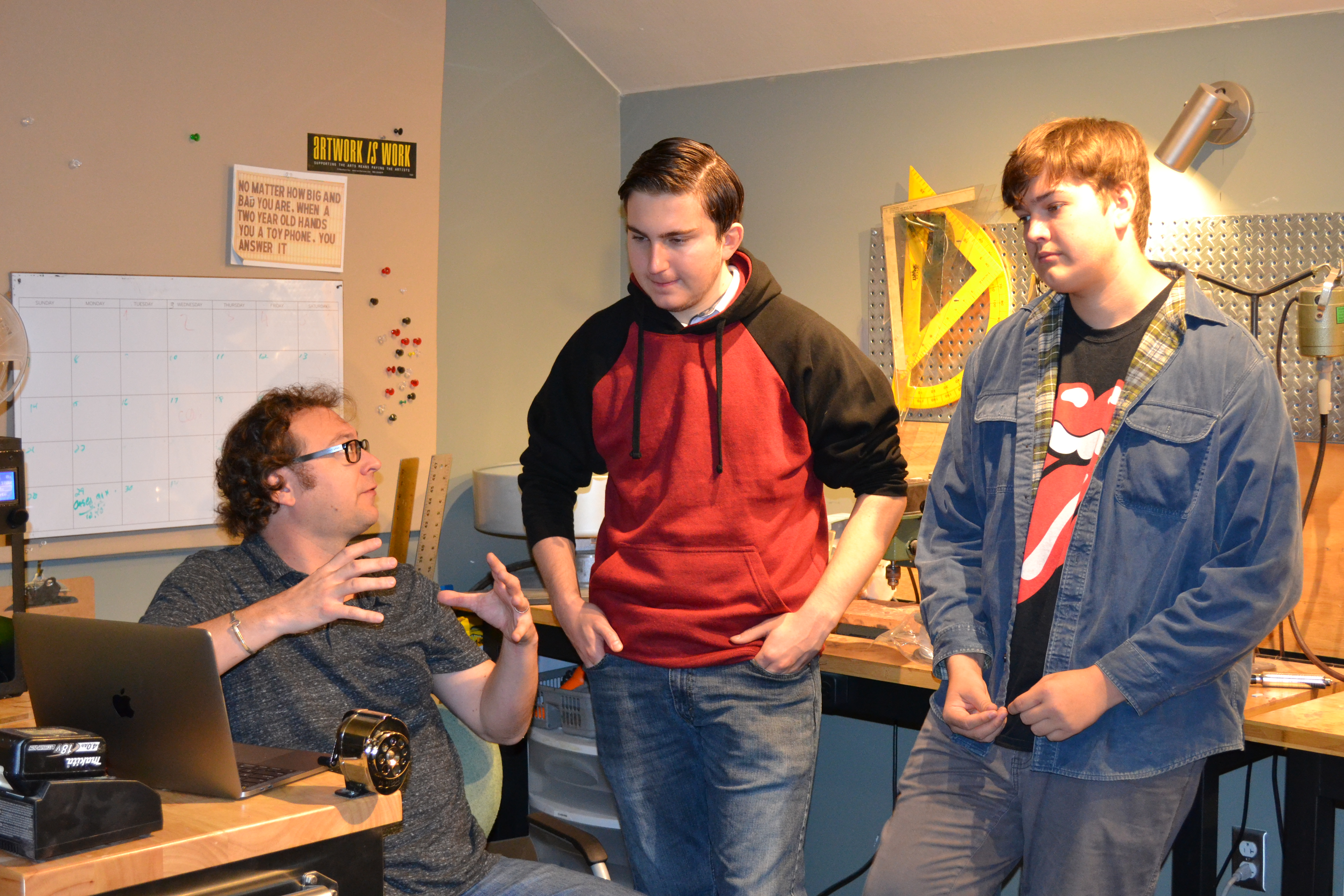 Instructor talking to students in makerspace