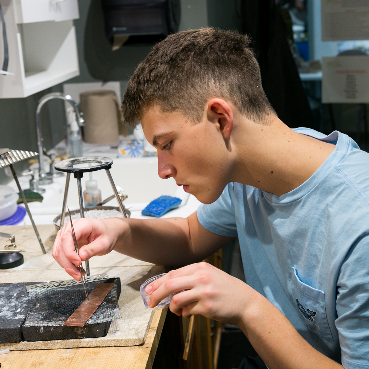 Student working with tweezers at metal smithing bench
