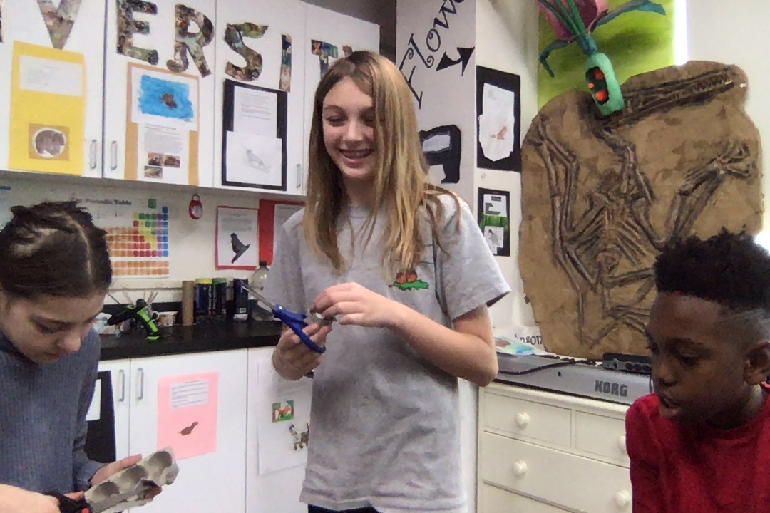 three students working on group project in classroom