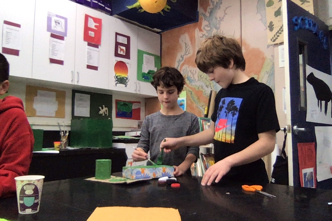 Two students in a classroom working on science