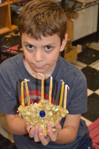 Student with candle holder he made in class