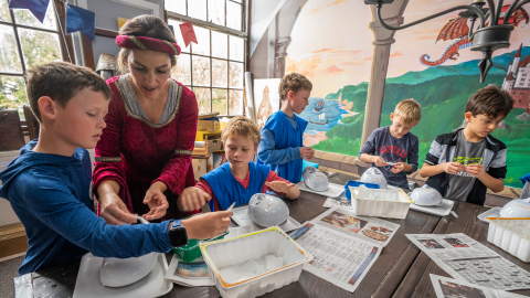 students at art table with teacher dressed like renaissance lady