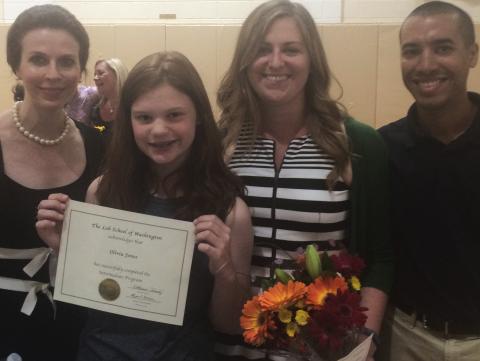 Olivia Jones in Sixth grade holding a certificate and surrounded by three other people
