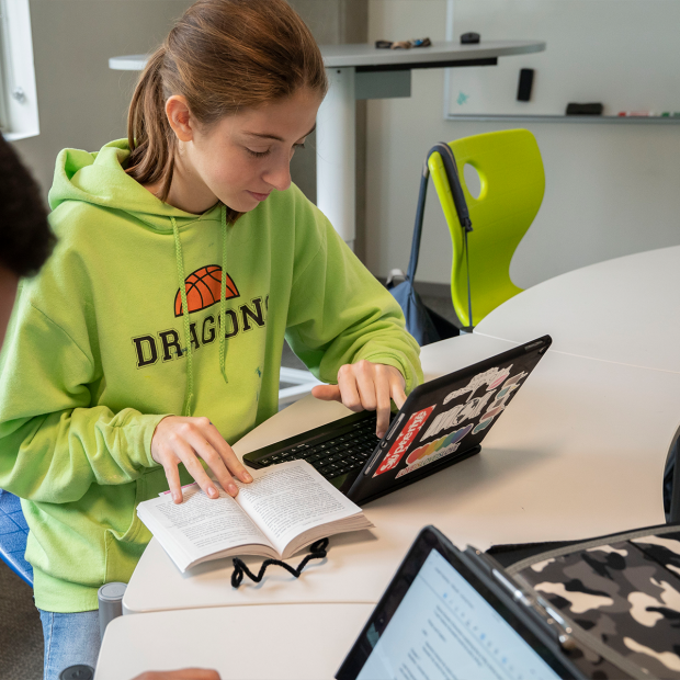 Female student at desk reading a book