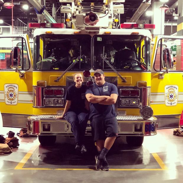 EMTs leaning on firetruck 