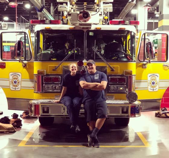 EMTs leaning on firetruck 