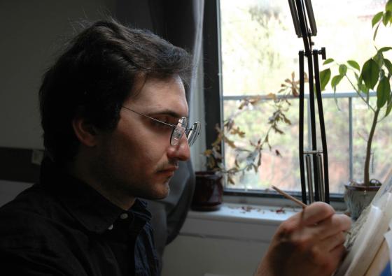 Man in glasses at an easel