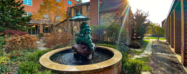 Fountain with statute of dragon holding umbrella and reading to child