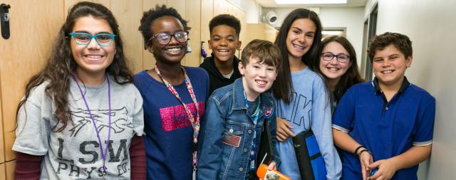 A group of junior high students pose in the hallway