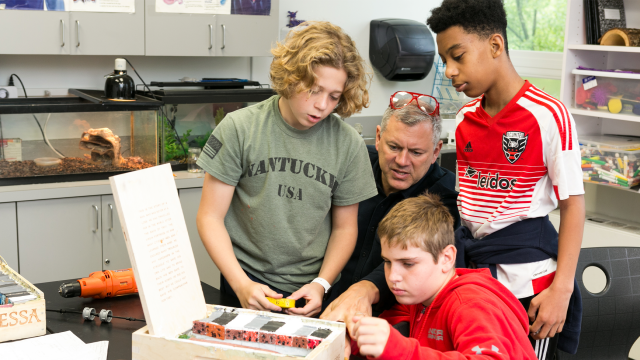 Students and teacher work on science project together