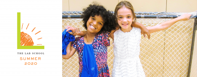 Two girls leaning against indoor goal net and smiling