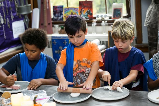 Three students working in art class at table