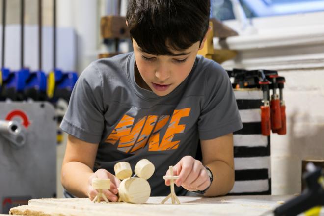 Lab student making drum set model out of wood