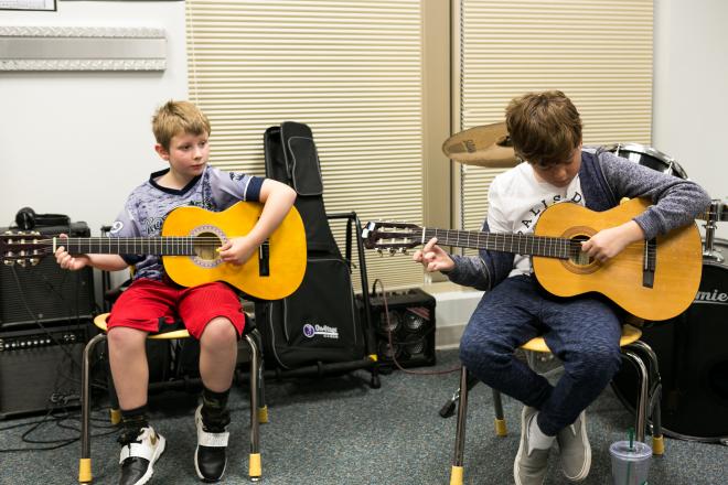 Two students playing guitar