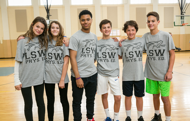 Six students standing together in the gym