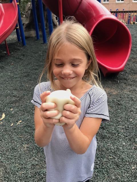 girl on playground squeezing something squishy