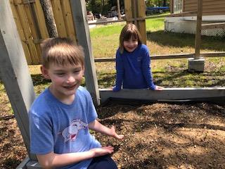 Two young students sit in the garden