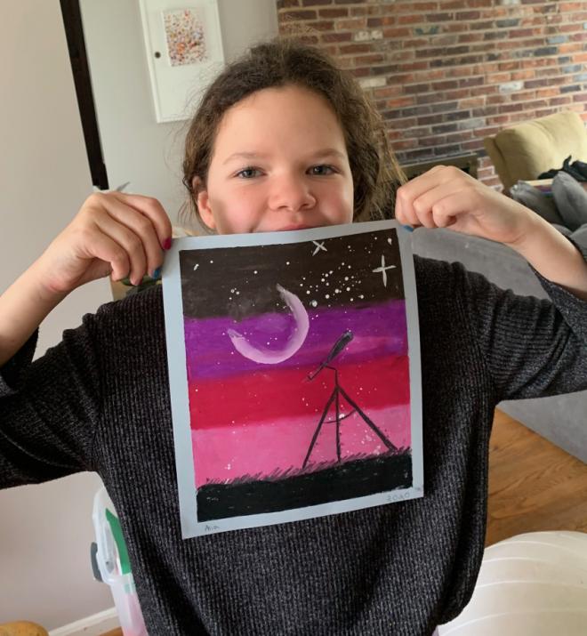 student holding up painting she made of Night sky