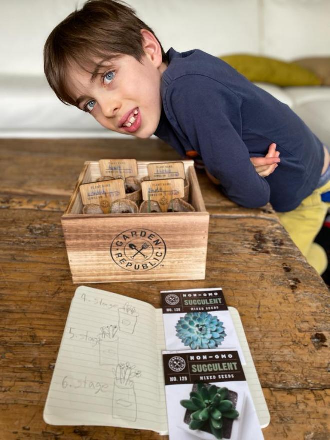 student poses with packages of succulent seeds