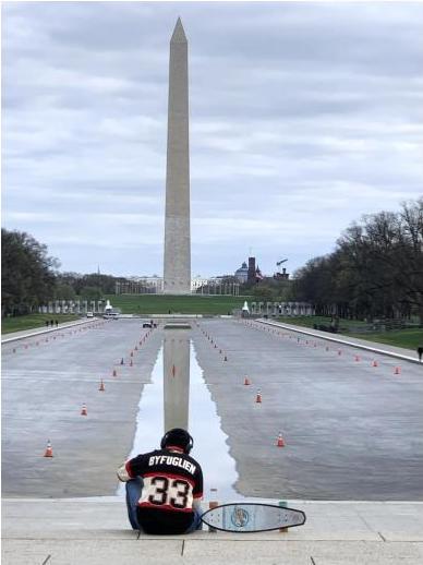 student sitting by Washington monument
