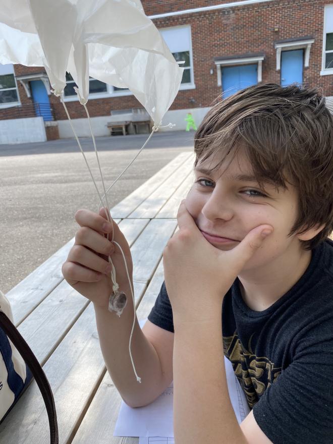 student smiling holding a mini parachute