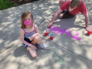 Drawing chalk messages on school driveway