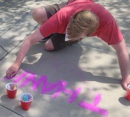 Drawing chalk messages on school driveway