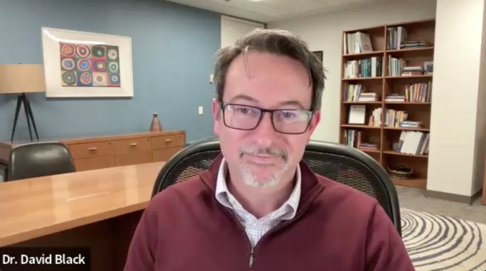 Screenshot of Dr. Black on Zoom sitting in his office with bookshelf behind him
