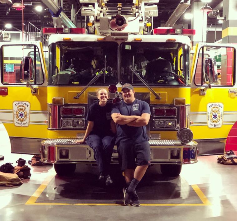 EMTs leaning on firetruck 